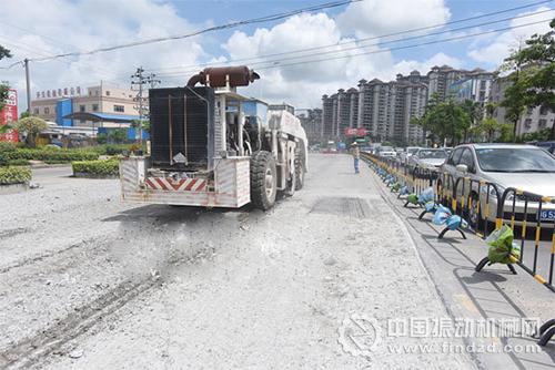  一輛大型共振破碎機(jī)行駛過后，路面留下一行共振破碎的水泥碎石